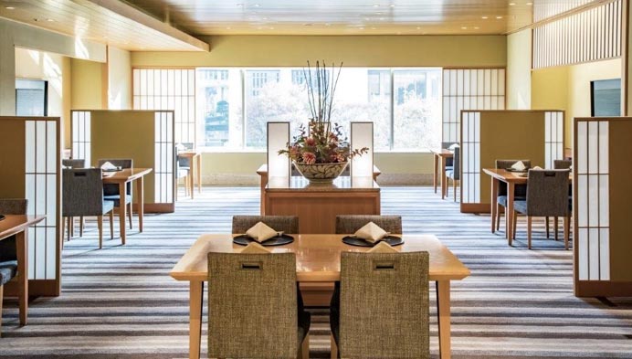 花束で飾られた披露宴会場に立つ着物姿の花嫁